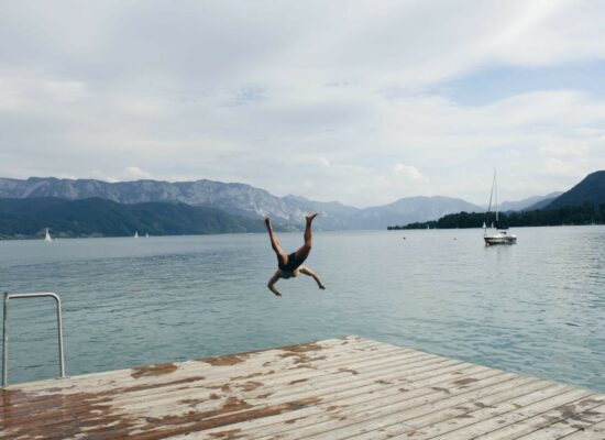 man jumping in a lake and having fun